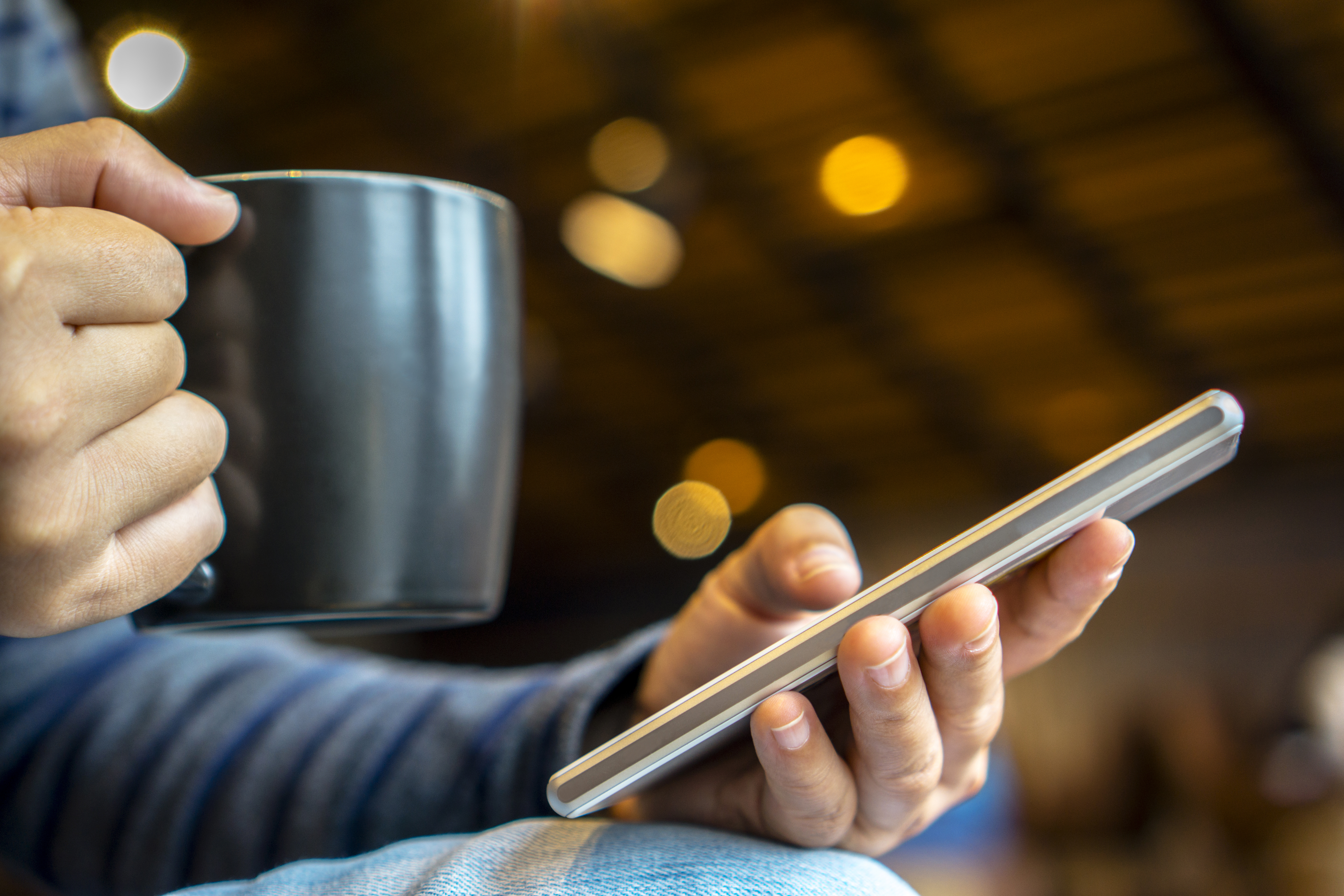 reading smartphone while drinking coffee