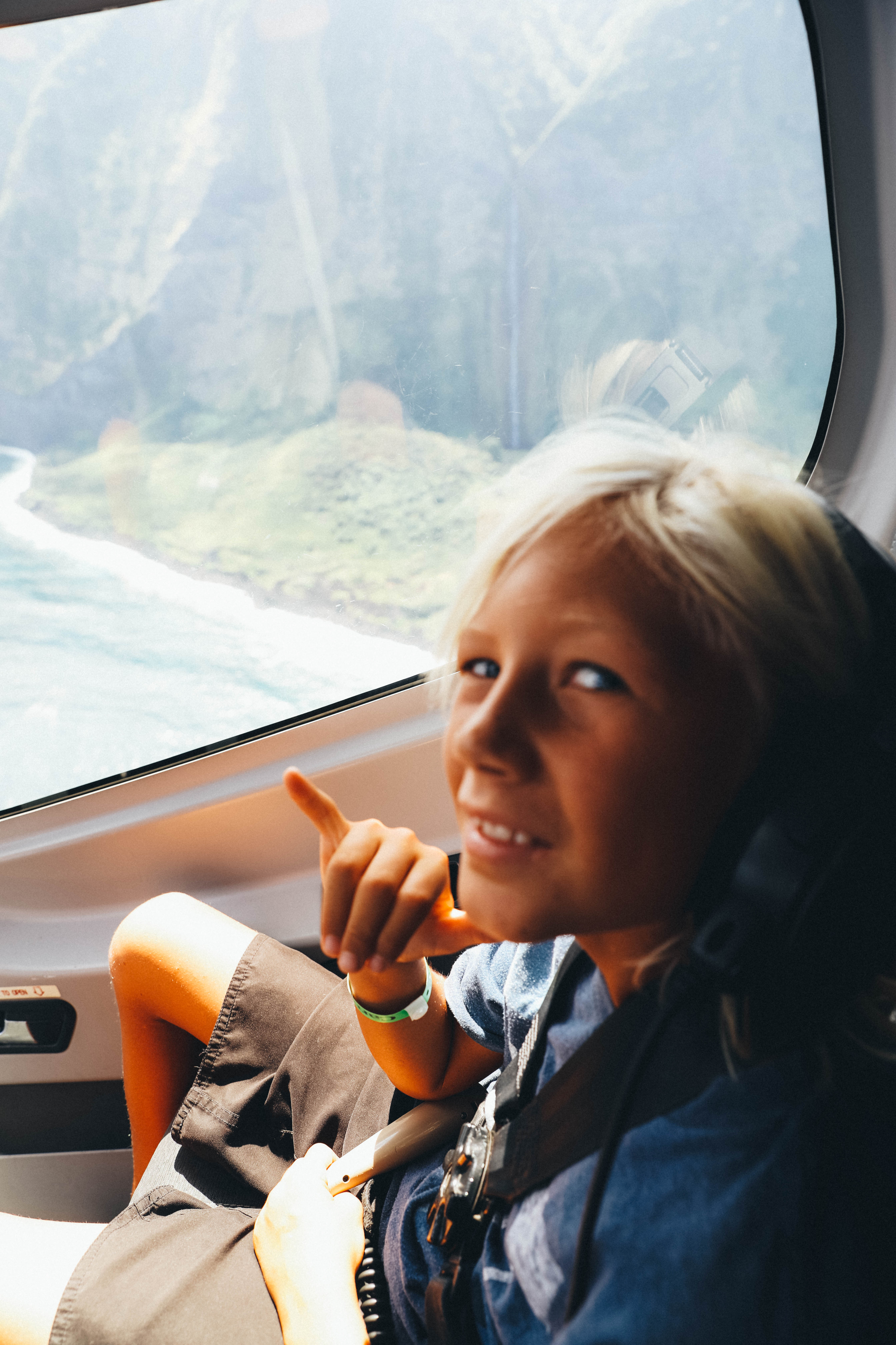 boy giving the hang loose sign with aerial view of Kona