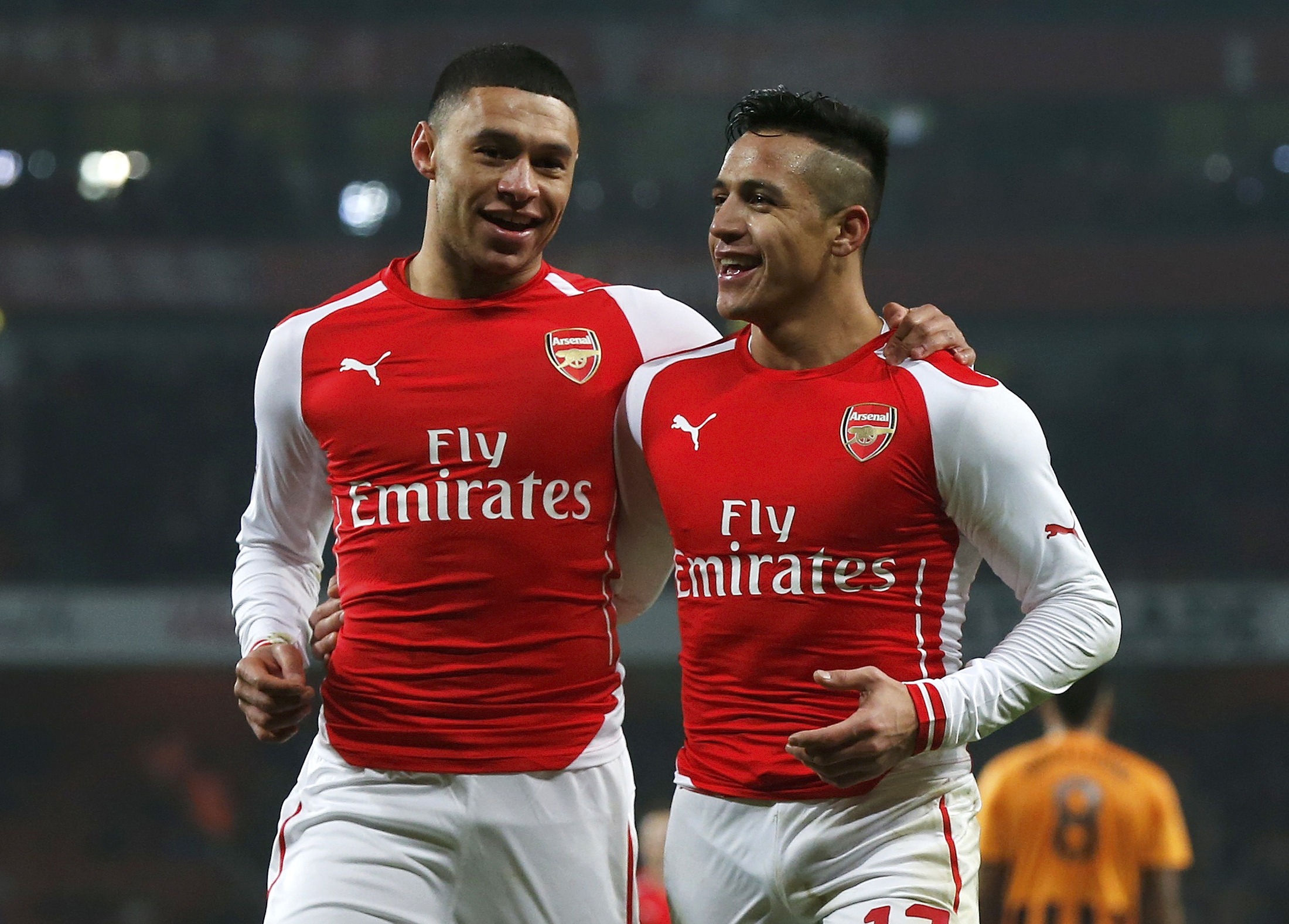 Alexis Sanchez of Arsenal celebrates with team mate Alex Oxlade-Chamberlain after scoring his team's second goal against Hull during their FA Cup third round soccer match at the Emirates Stadium in London