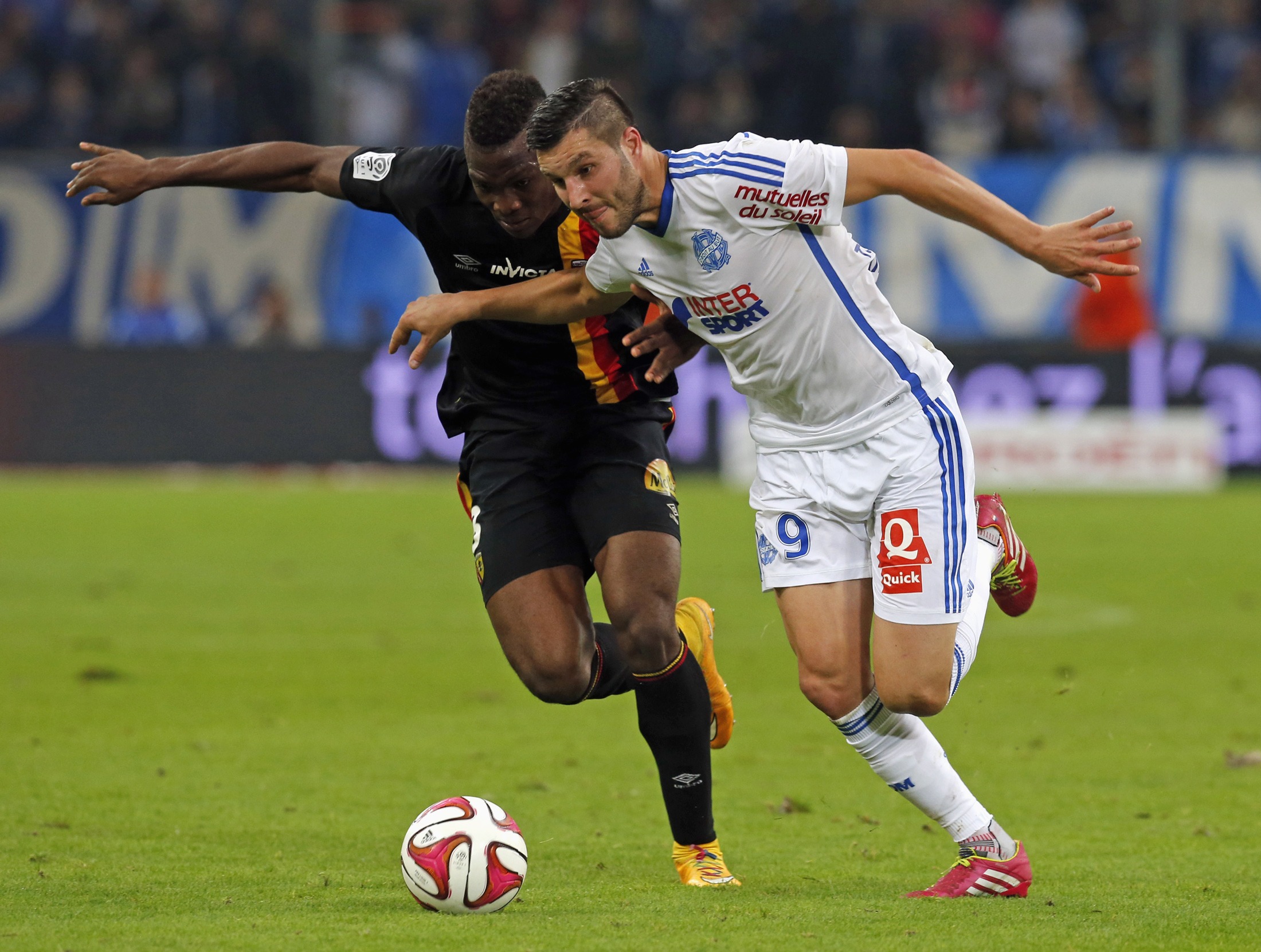 Olympique Marseille's Gignac challenges Cavare of RC Lens during their French Ligue 1 soccer match at the Velodrome stadium in Marseille